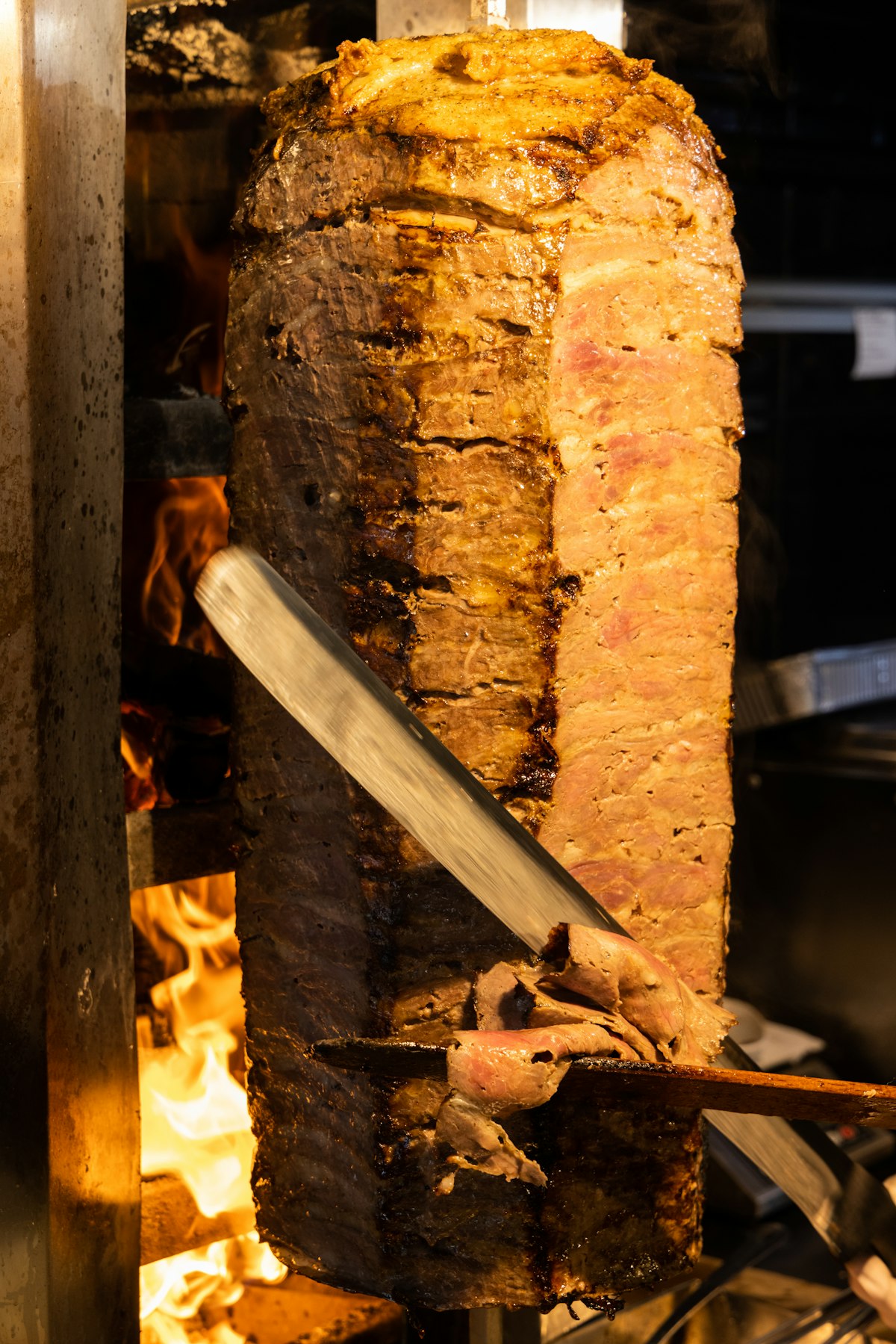 Close-up of doner meat roasting on a vertical spit